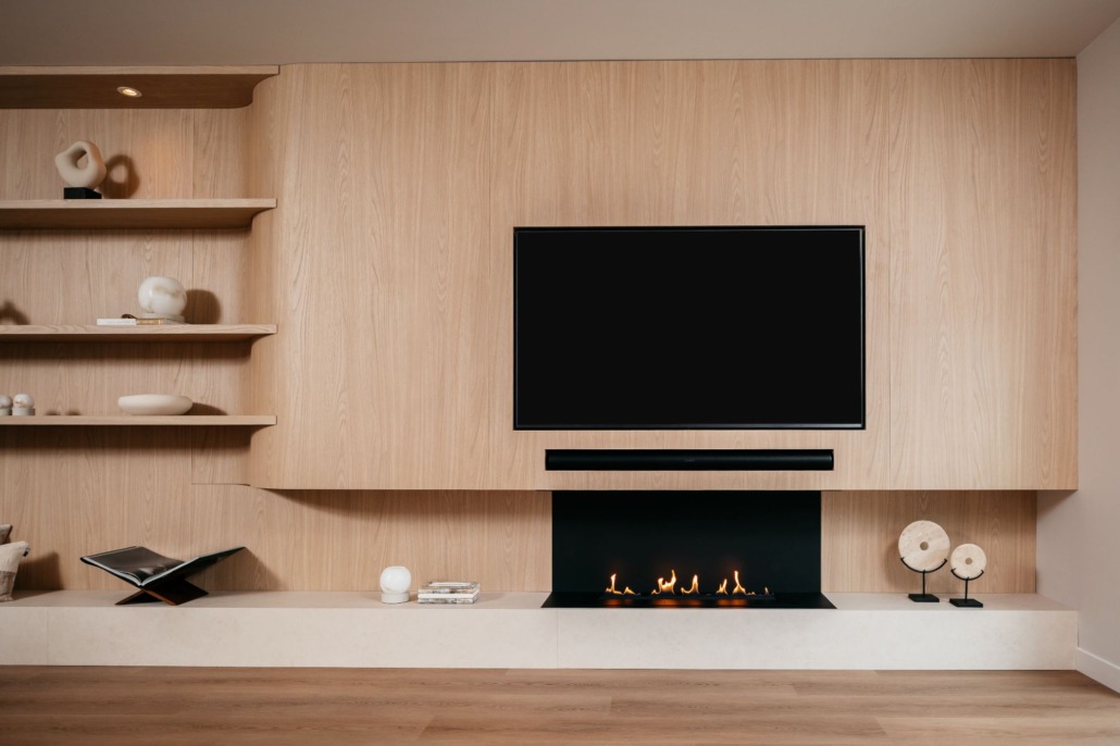 een luxe japandi cinewall in een licht eiken kleur met een tv, soundbar en elektrische haard.