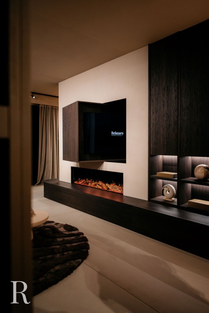 Een moderne woonkamer met een tv aan de muur boven een strakke, lineaire elektrische open haard, donkerhouten rekken met decoratieve voorwerpen en zachte verlichting die een gezellige sfeer creëert.