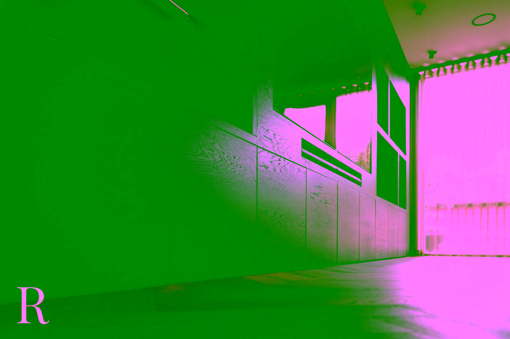 Loodrechte weergave van een modern, donkerhouten entertainmentmeubel met strakke lijnen in een kamer met ramen van vloer tot plafond en transparante gordijnen. Natuurlijk licht valt van rechts naar binnen en werpt zachte schaduwen op de houten vloer.