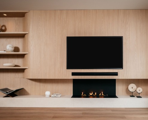 een luxe japandi cinewall in een licht eiken kleur met een tv, soundbar en elektrische haard.